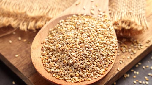 Spoonful of golden wholesome sesame seeds used for Crunchzilla authentic pantry